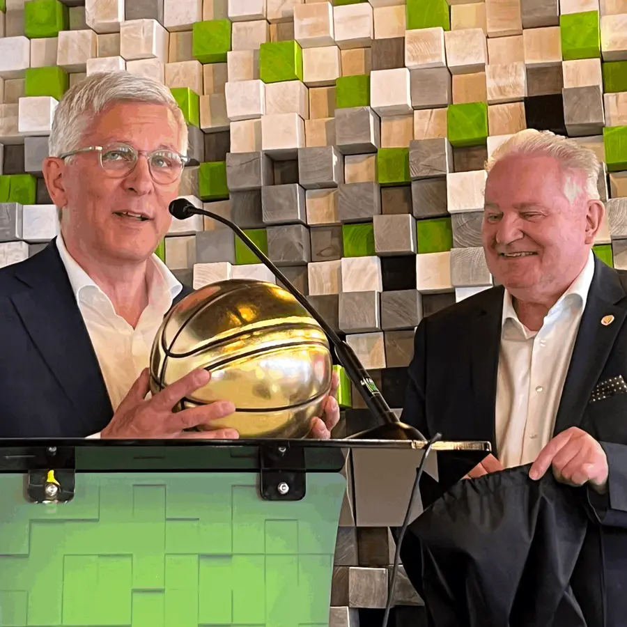 Oberbürgermeister Erik O. Schulz hält am Rednerpult einen goldenen Basketball in der Hand.