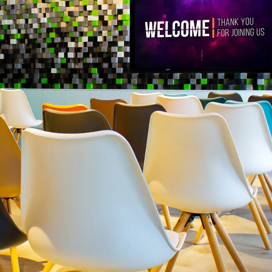 Seminarbestuhlung mit Stühlen und blick auf LED-Display mit Präsentation.