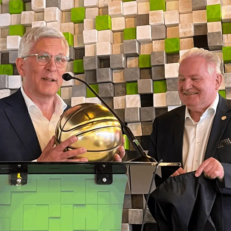 Oberbürgermeister Erik O. Schulz hält am Rednerpult einen goldenen Basketball in der Hand.